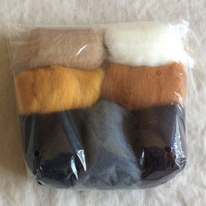 May include: A package of five different colors of wool roving. The colors are beige, yellow, brown, dark gray, and white.