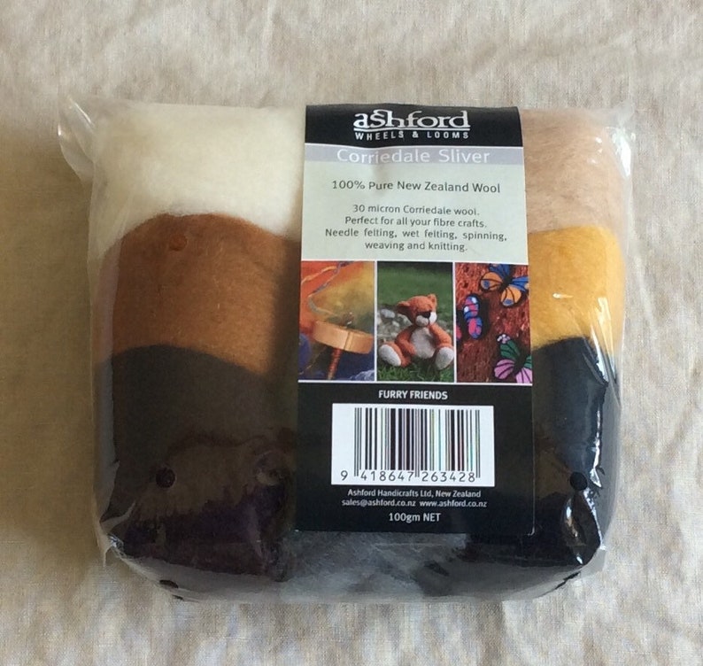 May include: A package of Corriedale wool sliver in white, brown, yellow, and black colors. The package is labeled "Ashford Wheels & Looms Corriedale Sliver 100% Pure New Zealand Wool 30 micron Corriedale wool. Perfect for all your fibre crafts. Needle felting, wet felting, spinning, weaving and knitting. Furry Friends 100gm NET"