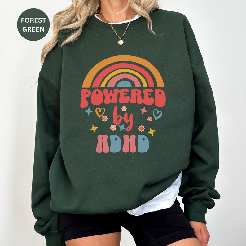 Woman wears Forest Green sweatshirt with slogan Powered By ADHD