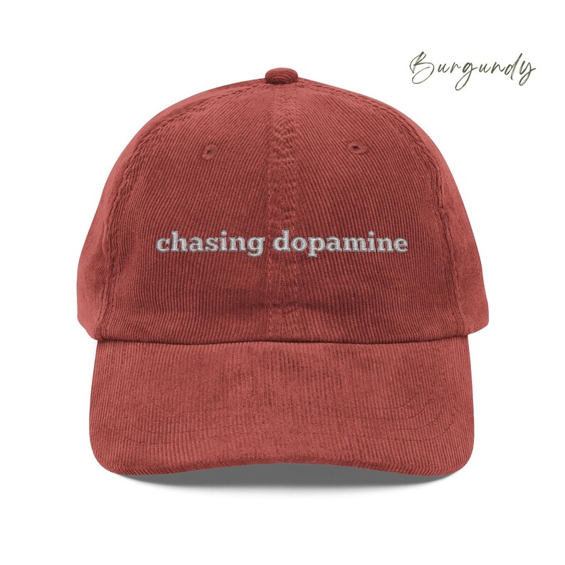 Vintage Corduroy dad hat in burgundy with embroidered text “chasing dopamine” in light grey thread . A minimalist, mental health inspired design.