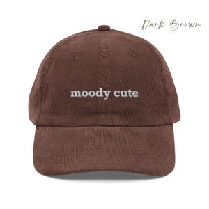 Dark Brown Corduroy Dad Cap with moody cute embroidered in light grey lettering. Unisex style adjustable sizing.