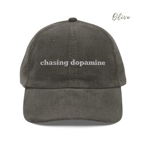 Vintage Corduroy dad hat in olive with embroidered text “chasing dopamine” in light grey thread . A minimalist, mental health inspired design.