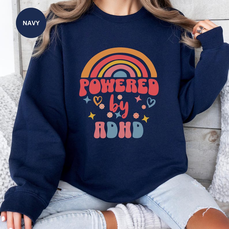 Woman wears Navy sweatshirt with slogan Powered By ADHD