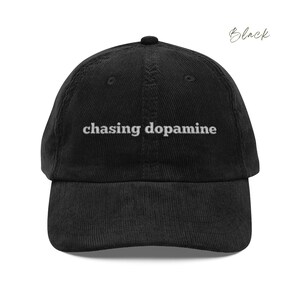 Vintage Corduroy dad hat in black with embroidered text “chasing dopamine” in light grey thread . A minimalist, mental health inspired design.