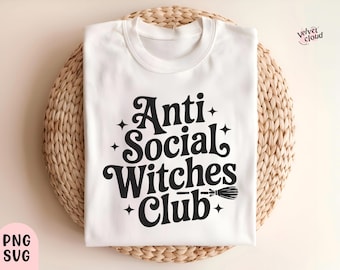 May include: White crew neck t-shirt with the text "Anti Social Witches Club" in black, along with star and broomstick graphics. The shirt is displayed on a woven, circular placemat. The Velvet Cloud logo is visible.
