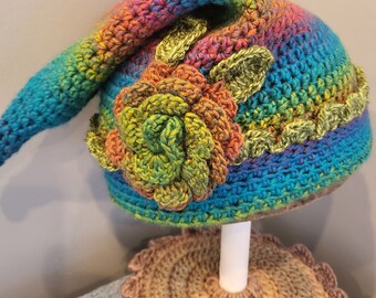 Rainbow inspired crochet pixie hat with flower and leaf embellishment