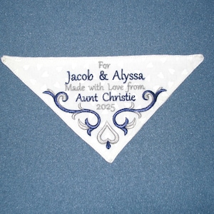 May include: White embroidered handkerchief with blue and silver thread. The text reads "For Jacob & Alyssa Made with Love from Aunt Christie 2025".
