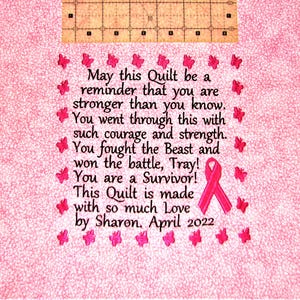May include: Pink quilted fabric with a pink ribbon and embroidered butterflies. The fabric has an embroidered message that reads: "May this Quilt be a reminder that you are stronger than you know. You went through this with such courage and strength. You fought the Beast and won the battle, Tray! You are a Survivor! This Quilt is made with so much Love by Sharon. April 2022"