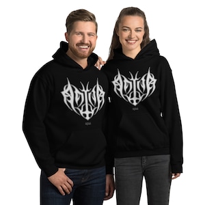 May include: Two black hoodies with a white graphic design of the word "ADIVA" in a stylized font. The graphic is in the shape of a heart with a cross in the center.