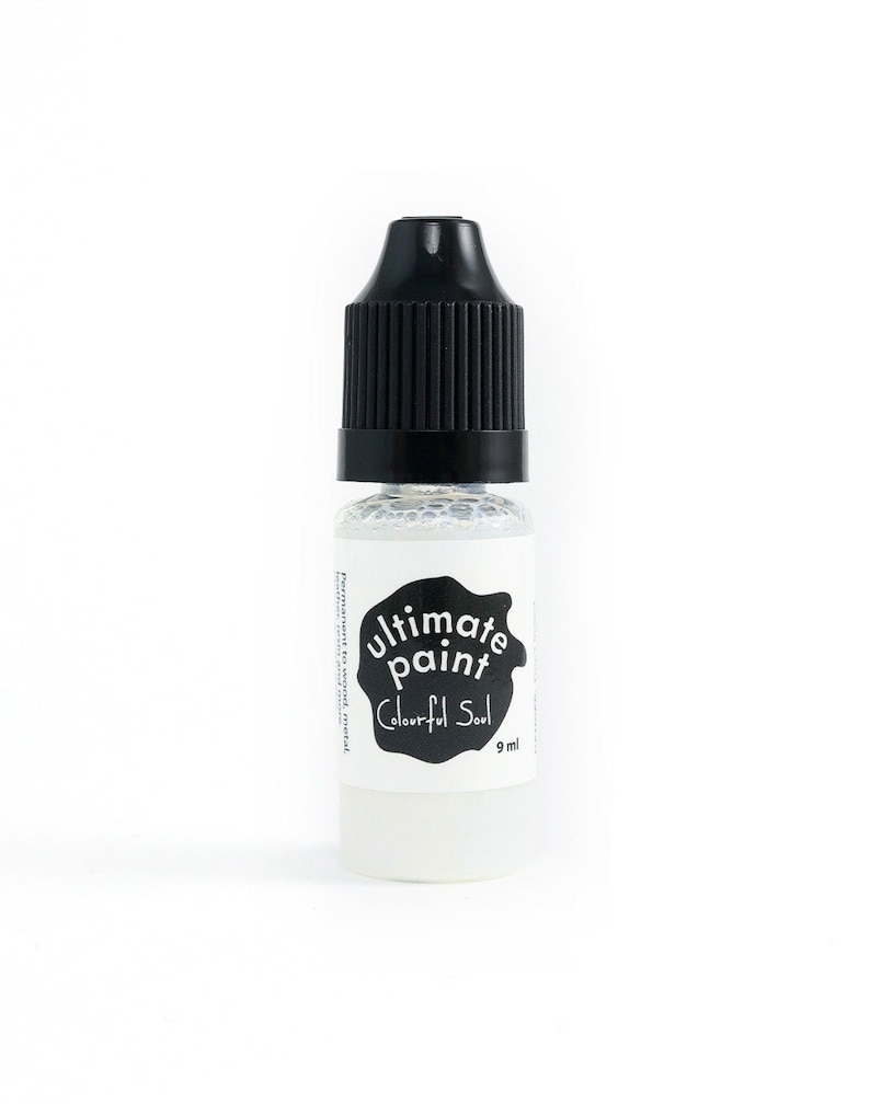 May include: A small clear bottle with a black cap containing white paint. The bottle has a black and white label that says "ultimate paint" and "Colourful Soul" with a 9 ml size indication.