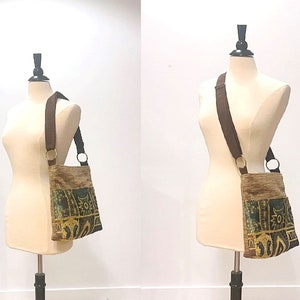 May include: A brown and gold tapestry-style crossbody bag with a brown strap. The bag has a geometric pattern with green, yellow, and brown accents.