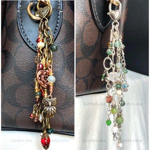 May include: Two bag charms featuring metal chains and assorted beads. The left charm has bronze-toned metal, an owl pendant, and red beads. The right charm has silver-toned metal, a heart-shaped clasp, and green, white, and clear beads.