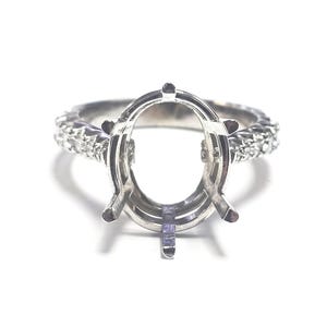 May include: A silver ring setting with an oval center and a band encrusted with small, sparkling stones. The ring is designed to hold a large, oval-shaped gemstone. The setting is shown against a white background.