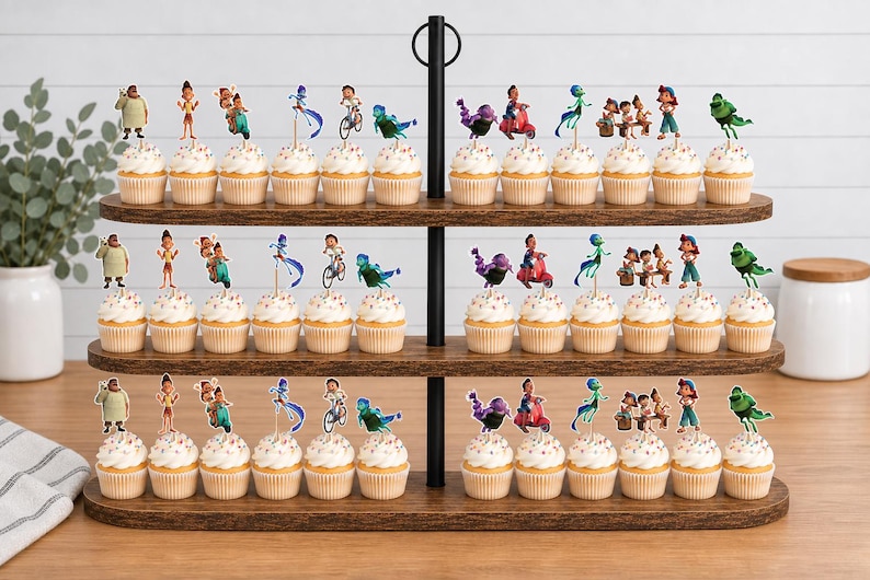 Puede incluir: Un soporte de madera para cupcakes de tres niveles con treinta y seis cupcakes, cada uno decorado con un peque&ntilde;o recorte de papel que muestra varios personajes animados de la pel&iacute;cula Luca, incluyendo figuras en bicicleta, en scooter y como monstruos marinos.