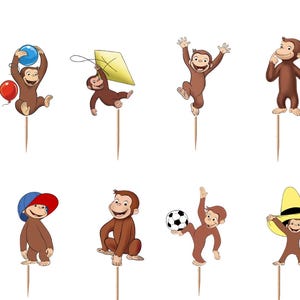 May include: A set of twelve decorative cupcake toppers featuring brown monkeys in various poses, including holding a banana, a red balloon, a blue balloon, a yellow kite, a soccer ball, and wearing yellow or blue hats, each attached to a wooden pick.