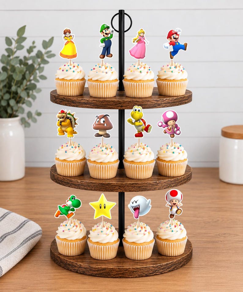 May include: A three-tiered wooden cupcake stand holding twelve cupcakes, each topped with a white frosting swirl and a colorful paper cutout of a Super Mario character, including Mario, Luigi, Princess Peach, Daisy, Bowser, Toad, and a star.