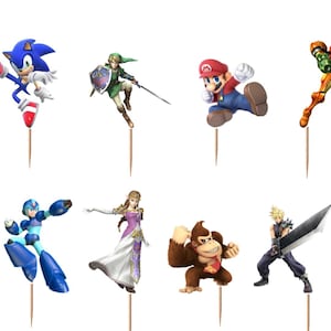 Pu&ograve; includere: Un set di dodici decorazioni per cupcake raffiguranti vari personaggi colorati dei videogiochi, tra cui Fox, Sonic, Link, Mario, Samus, Pikachu, Bowser, Mega Man, Zelda, Donkey Kong, Cloud e Ken, ciascuno fissato su uno stuzzicadenti in legno.