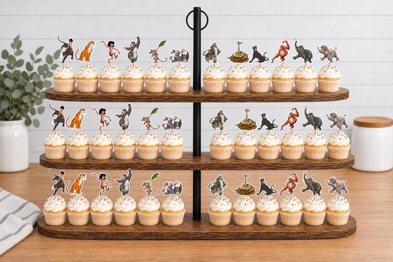 May include: A three-tiered wooden cupcake stand holding rows of cupcakes topped with paper character cutouts. The decorations feature various jungle animals and human figures in colorful illustrations, each attached to a small wooden pick.