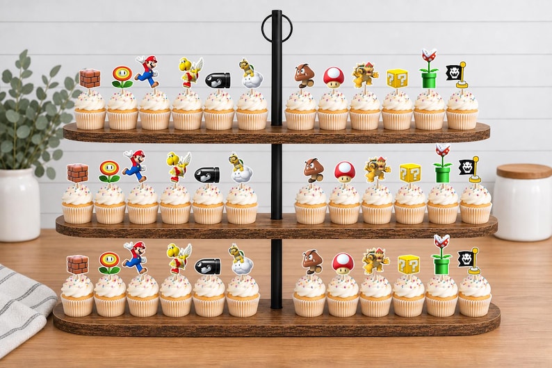 May include: A three-tiered wooden stand holding numerous cupcakes, each topped with a decorative paper cutout featuring various Super Mario characters and icons, including Mario, Goombas, mushrooms, question blocks, and piranha plants.