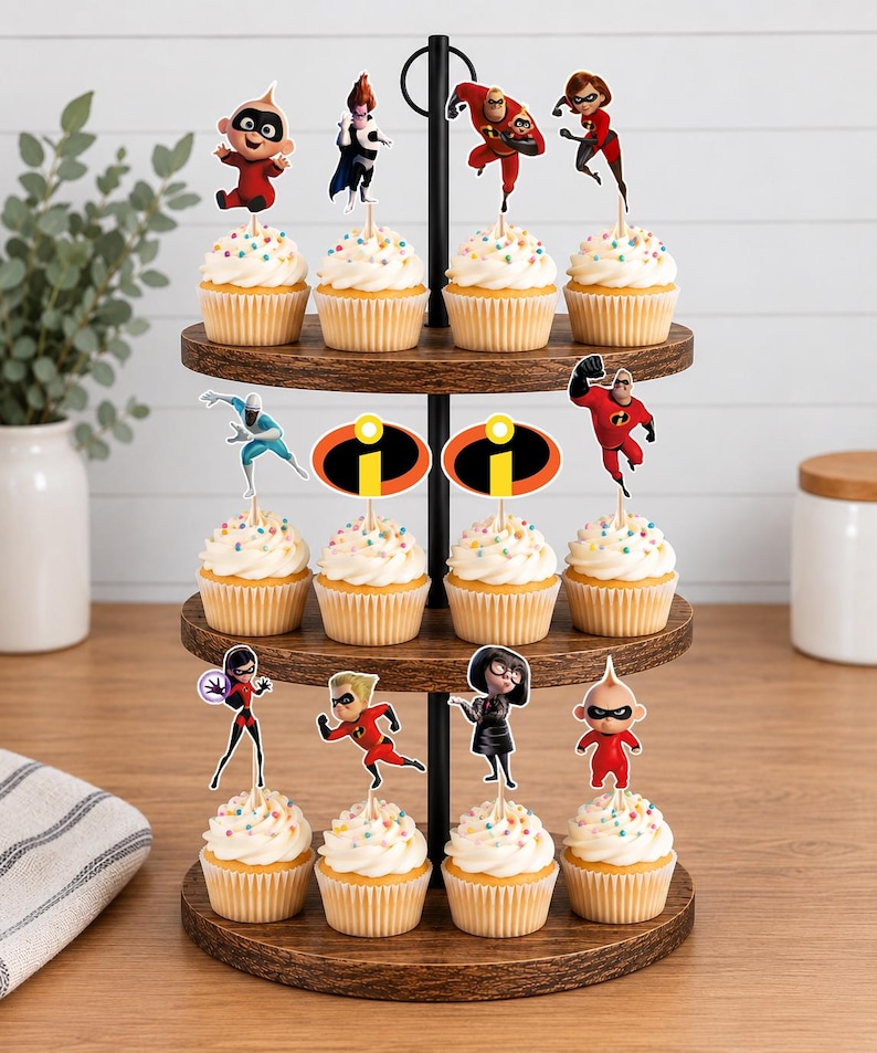 Op de afbeelding: Een houten cupcake-standaard met drie niveaus en twaalf cupcakes, voorzien van witte glazuur en kleurrijke hagelslag. Elke cupcake heeft een papieren topper met personages en logo's uit The Incredibles, waaronder Mr. Incredible, Elastigirl, Violet, Dash, Jack-Jack, Edna Mode, Frozone en het oranje-gele logo.