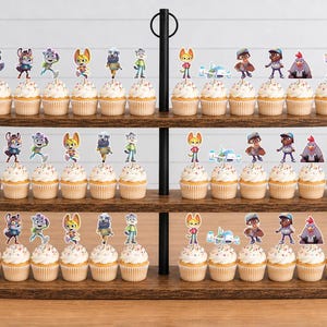 Puede incluir: Un soporte de madera para cupcakes de tres niveles con filas de cupcakes decorados con coloridos adornos de papel de personajes animados. La exhibici&oacute;n presenta varias figuras, incluyendo animales y robots, en cada nivel del soporte.