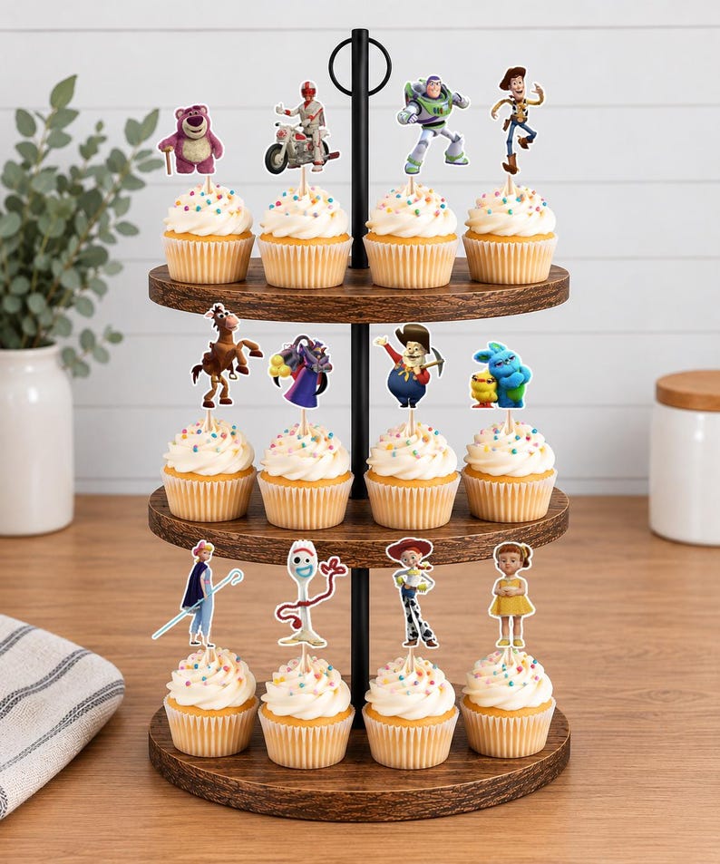 Puede incluir: Un soporte de madera para cupcakes de tres niveles con doce cupcakes, cada uno cubierto con un remolino de glaseado blanco, chispas de colores y un recorte de papel de un personaje de Toy Story, incluyendo a Woody, Buzz Lightyear y Forky.