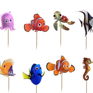 May include: A set of twelve decorative cupcake toppers featuring various colorful sea creatures including a shark, octopus, clownfish, sea turtle, angelfish, starfish, and stingray, each attached to a thin wooden pick for insertion into food items.