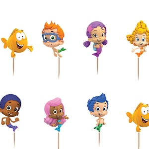 May include: A set of twelve decorative cupcake toppers featuring Bubble Guppies characters and circular blue logos with the text Bubble Guppies. Each topper is attached to a thin wooden pick, showcasing various animated figures in bright colors.