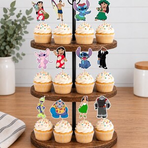 May include: A three-tiered wooden cupcake stand holding twelve cupcakes topped with colorful sprinkles and paper character toppers featuring Lilo, Stitch, and various other animated figures from the Lilo and Stitch franchise on wooden picks.
