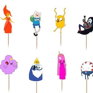 May include: A collection of Adventure Time character toppers, including Finn, Jake, Princess Bubblegum, and others. Each character is depicted in a colorful, cartoon style, mounted on a wooden stick, perfect for decorating cakes or cupcakes.