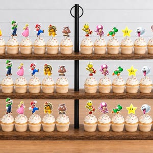May include: A three-tiered wooden cupcake stand holding thirty-six cupcakes, each topped with a paper cutout of a Super Mario character, including Mario, Luigi, Princess Peach, Bowser, Goomba, Koopa Troopa, Toadette, Yoshi, a star, Boo, and Toad.
