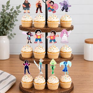 Puede incluir: Un soporte de madera para cupcakes de tres niveles con doce cupcakes, cada uno decorado con un recorte de papel de un personaje de Steven Universe. Los personajes incluyen a Steven, Garnet, Amethyst, Pearl, Rose Quartz, Peridot, Lapis Lazuli, Connie y Jasper.