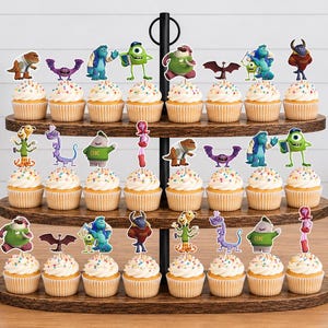May include: A three-tiered wooden cupcake stand holding twenty-four cupcakes, each topped with a colorful paper cutout of a character from the Monsters University film. The stand features a central black metal handle and a dark brown wood grain finish.