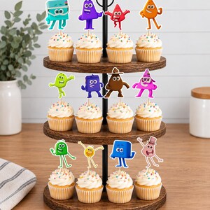 May include: A three-tiered wooden cupcake stand holding twelve cupcakes topped with white frosting and colorful sprinkles. Each cupcake features a unique, colorful cartoon character topper in various shapes including squares, triangles, and circles.