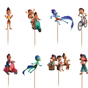 Puede incluir: Un conjunto de doce adornos para cupcakes con varios personajes animados de la pel&iacute;cula Luca, incluyendo formas humanas y de monstruos marinos, montando scooters, bicicletas o nadando, cada uno unido a un palillo de madera para su inserci&oacute;n.
