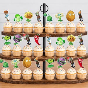 May include: A three-tiered wooden cupcake stand holding twenty-four cupcakes, each topped with a decorative paper cutout featuring characters and plants from the Plants vs. Zombies game, including sunflowers, walnuts, chili peppers, and various zombies.