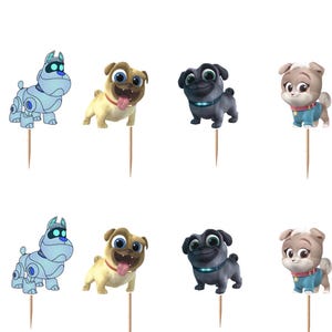 Puede incluir: Un conjunto de adornos para cupcakes de Puppy Dog Pals con personajes de dibujos animados, incluyendo un perro robot azul claro, un pug beige, un pug negro, un cachorro marr&oacute;n claro y un gato morado, unidos a palillos de madera finos.