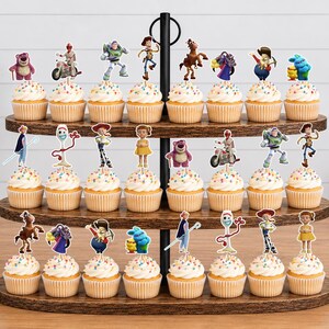 Puede incluir: Un soporte de madera para cupcakes de tres niveles con veinticuatro cupcakes, cada uno decorado con un peque&ntilde;o recorte de papel colorido de varios personajes de Toy Story, incluidos Buzz Lightyear, Woody, Forky y Lotso.