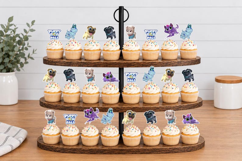 Puede incluir: Un soporte de madera de tres niveles para cupcakes con veinticuatro unidades decoradas con figuras de Puppy Dog Pals. Cada cupcake tiene un adorno de papel que muestra varios cachorros animados y el logotipo de Puppy Dog Pals.