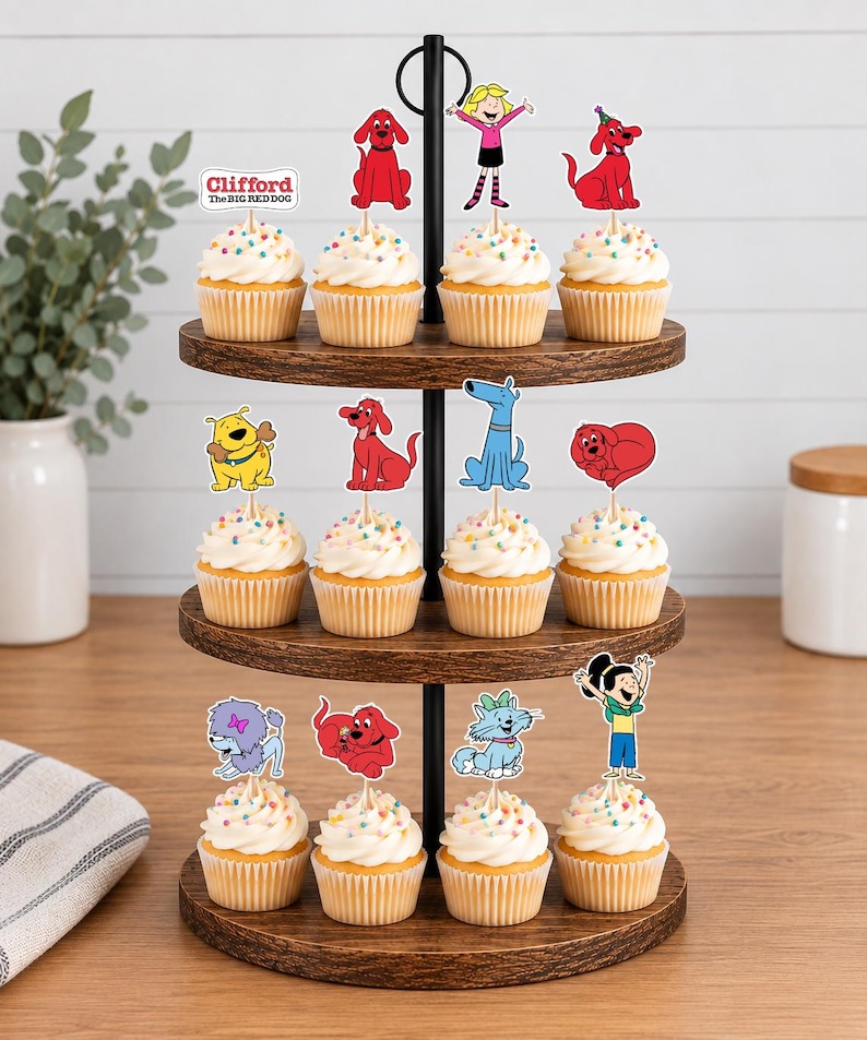 Pode incluir: Um suporte de madeira de tr&ecirc;s n&iacute;veis para cupcakes com doze bolinhos cobertos com glac&ecirc; branco e granulado colorido. Cada cupcake possui um topo de papel com personagens de Clifford, o c&atilde;o vermelho, incluindo Clifford e seus amigos animais.