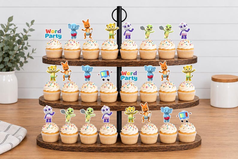 Puede incluir: Un soporte de madera de tres niveles para cupcakes con veintid&oacute;s pastelitos decorados con figuras de papel de los personajes de Word Party. Los adornos muestran animales de dibujos animados como un panda, un elefante, un canguro y un guepardo.