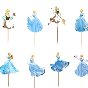 May include: A set of twelve decorative cupcake toppers featuring various illustrations of Cinderella in different outfits, including a blue ball gown and a brown and white work dress, each attached to a thin, pointed wooden pick for insertion.