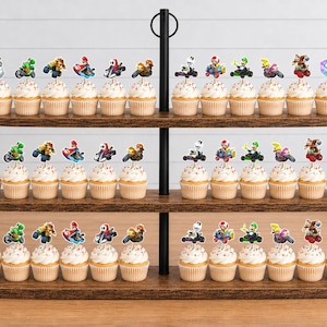 Op de afbeelding: Een houten etag&egrave;re met drie lagen gevuld met cupcakes, elk voorzien van papieren decoraties met Mario Kart-personages, voertuigen en een blauw vraagtekenblok, bevestigd op houten prikkers die in de topping zijn gestoken.
