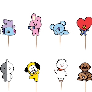 Peut inclure: Un ensemble de d&eacute;corations pour cupcakes BT21 sur des pics en bois. La collection comprend Mang, Cooky, Koya, Tata, Van, Chimmy, RJ et Shooky, ainsi que quatre panneaux rectangulaires avec le texte noir BT21 sur fond blanc.