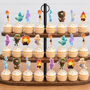 May include: A three-tiered wooden cupcake stand holding twenty-four cupcakes, each topped with a colourful character cutout from the movie Elemental. The cupcakes feature white frosting with multicoloured sprinkles, arranged on dark brown wood shelves.