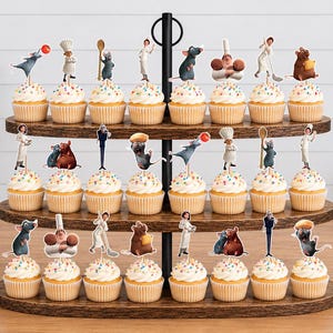 May include: A three-tiered wooden cupcake stand holding twenty-four cupcakes, each topped with a colorful paper cutout featuring characters and culinary items from the movie Ratatouille, including rats, chefs, and kitchen utensils on white frosting.