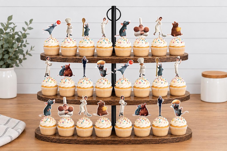 May include: A three-tiered wooden cupcake stand holding twenty-four cupcakes, each topped with a colorful paper cutout featuring characters and culinary items from the movie Ratatouille, including rats, chefs, and kitchen utensils on white frosting.