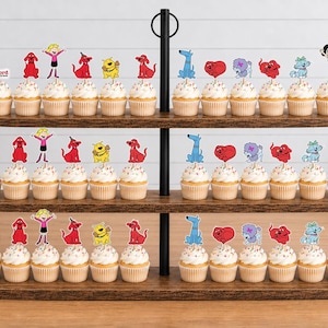 Pode incluir: Um suporte de madeira para cupcakes de tr&ecirc;s n&iacute;veis com v&aacute;rios cupcakes decorados com recortes de papel coloridos das personagens de Clifford, o c&atilde;o vermelho, incluindo Clifford, Emily Elizabeth e v&aacute;rios outros c&atilde;es.