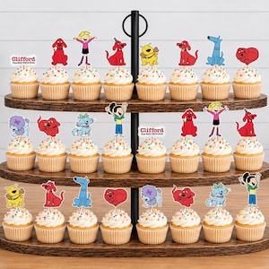 Pode incluir: Um suporte de madeira para cupcakes de tr&ecirc;s n&iacute;veis com vinte e quatro cupcakes decorados com topos de papel coloridos apresentando personagens de Clifford, o Gigante C&atilde;o Vermelho, incluindo Clifford, Emily Elizabeth e v&aacute;rios c&atilde;es.