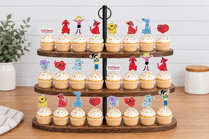 Pode incluir: Um suporte de madeira para cupcakes de tr&ecirc;s n&iacute;veis com vinte e quatro cupcakes decorados com topos de papel coloridos apresentando personagens de Clifford, o Gigante C&atilde;o Vermelho, incluindo Clifford, Emily Elizabeth e v&aacute;rios c&atilde;es.